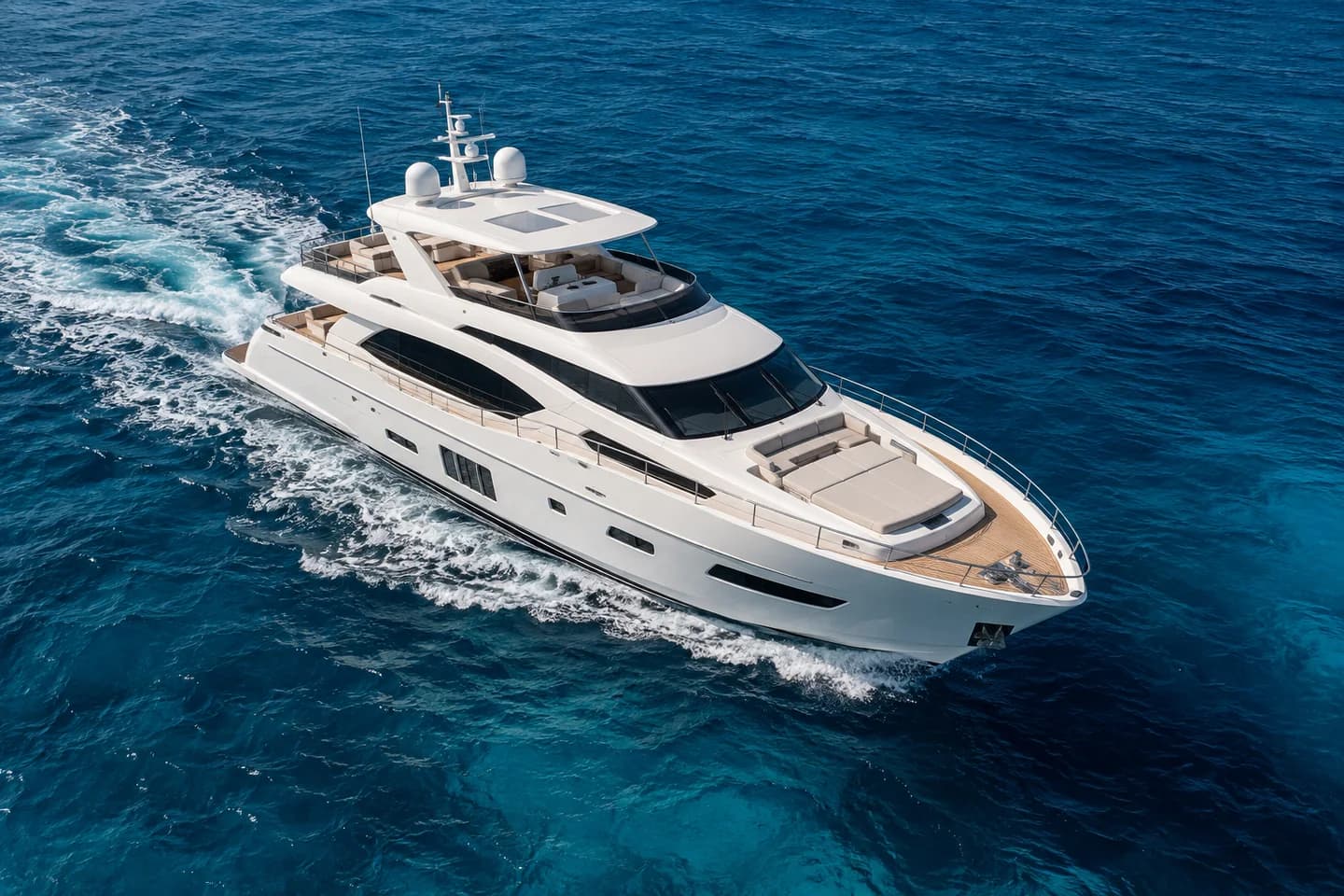 Aerial view of a white motor yacht cruising through turquoise Mediterranean waters